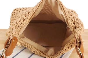 Close-up of woven bag interior showing fabric lining, top zipper, and metal hardware