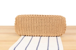Detail of the sturdy woven bottom and thick cord texture of this straw summer bag