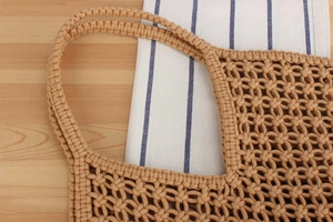 Close-up of hollow mesh hand-woven bag texture and sturdy dual handle craftsmanship