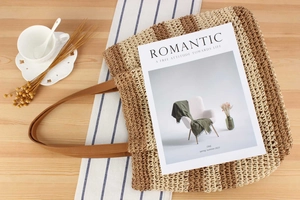 Close-up of a striped woven tote bag with leather handles on a rustic wooden table