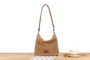 Detailed hollow mesh weave pattern on a beige shoulder bag with slim leather straps
