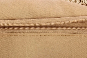 Macro shot of durable nylon zipper and stitch details on large woven canvas tote bag