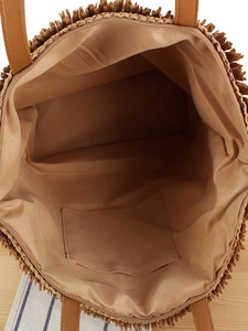Straw woven tote bag with fringe edge and zip closure shown from a top-down interior angle