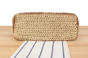 Close-up of the textured woven straw bag showing detailed fiber patterns and craftsmanship