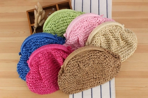 Detail of woven straw clutch bags in multiple colors like green, pink, and blue