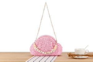 Detail of pink hand-woven cloud shoulder bag with marble bead handle and gold chain strap