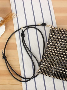 Fashionable black and gold woven handbag with metallic texture and leather shoulder strap