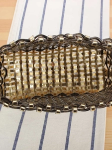 Detailed top view of handmade woven tote bag with gold metallic finish and interior texture