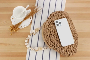 Detail of heart-shaped woven bag with marble-pattern acrylic handle and smartphone scale