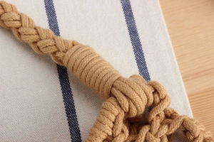 Macro detail of natural hand-woven cotton rope texture and reinforced handle craftsmanship