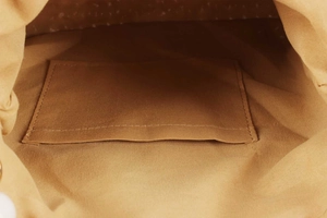 Close-up of internal canvas pocket and precise stitching of the woven bag interior