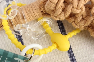 Detail of yellow spiral silicone lanyard and clear links on a woven cotton phone bag