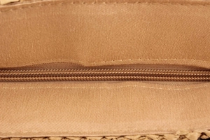 Close-up of woven bag interior featuring textured fabric lining and matching nylon zipper