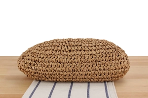 Detailed bottom view of woven straw tote bag showing fine craftsmanship and natural fiber texture