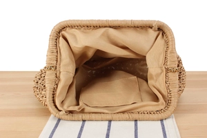 Vista dettagliata della pochette in paglia con fodera, tasca interna e chiusura in metallo oro