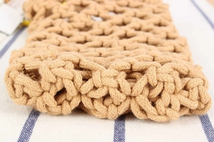 Macro detail of hand-woven cotton rope mesh on casual fashion bag over striped background