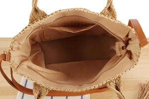 Detail view of woven straw tote bag interior with fabric lining and functional pockets
