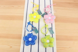 Close-up of colorful plush flower charms with plastic hooks and Flower brand tags