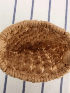 Vertical top view of a handmade woven cotton rope handbag with thick natural brown texture