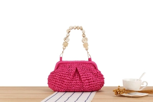 Detail of hot pink crochet bag with decorative marble-textured beaded handle
