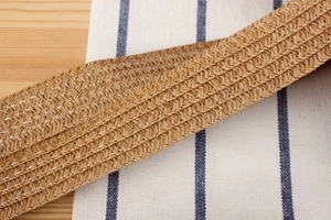 Detailed macro view of high-quality woven straw material with white cross-stitch reinforcement
