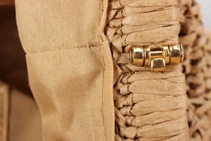 Macro detail of khaki straw woven texture with golden metal hardware and premium lining