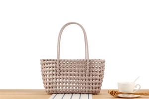 Detail of hollow woven tote bag with wide flat straps and rectangular mesh pattern
