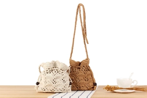 Detail of hand-woven crochet drawstring bags in beige and coffee with wooden beads