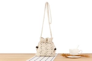 Detailed shot of handmade crochet bucket bag with hollow floral pattern and wooden beads