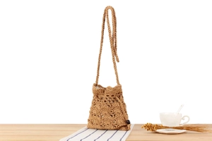 Detail of hand-woven cotton rope bucket bag with drawstring closure and bead accents