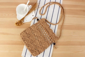 Detailed close-up of handmade crochet cotton rope bag with black decorative beads