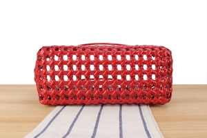 Detail of red hollowed-out woven basket bag with stylish leather-like mesh texture