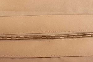 Detailed close-up of smooth nylon zipper and precise stitching on khaki woven bag
