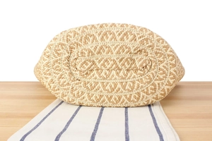 Detailed view of the woven texture and bottom structure of a handmade straw tote bag