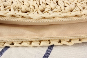 Detail of woven straw bag showing secure zipper closure and durable fabric lining