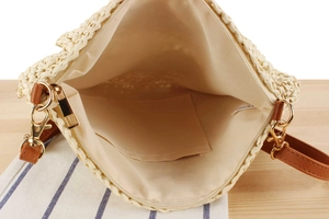 Internal view of a woven straw bag with beige fabric lining and a small pocket