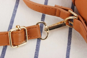 Detailed view of brown leather strap with golden metal hardware and neat stitching accents