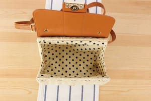 Detailed top view of a woven bag showing polka dot lining and golden hardware lock
