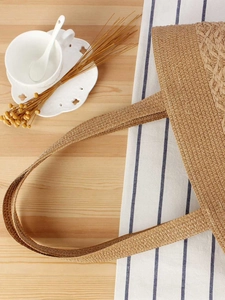 Summer woven straw tote bag with scalloped edges on a rustic cafe table setting