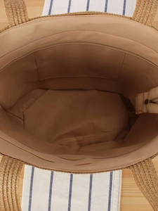 Top view of woven straw tote bag showing internal zipper pocket and fabric lining