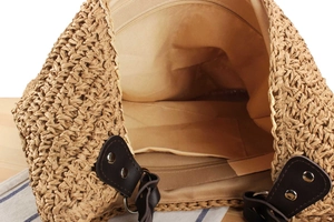 Macro detail of straw bag showing fabric lining, internal pocket and zipper closure