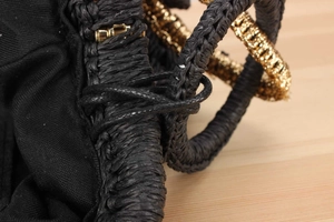 Close-up of black straw woven texture with golden metallic accents and fabric lining