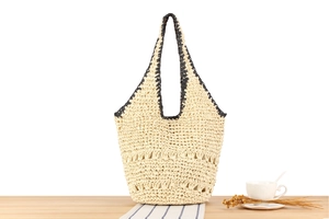 Detail of a woven tote bag with hollow patterns on a cozy wooden table set