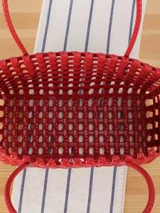 Red woven hollow basket bag with top view showing interior space for beach vacation