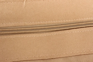 Macro detail of high-quality nylon zipper and durable khaki canvas stitching on bag