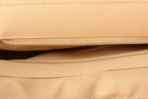 Detailed close-up of smooth nylon zipper and neat stitching on woven bag lining