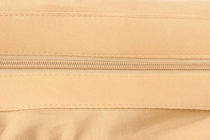 Close-up of a nylon zipper and precise stitching on the khaki woven shoulder bag