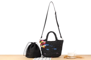 Close-up of black crochet tote with colorful accents, inner drawstring bag and leather strap