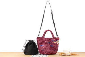 Detail of purple hand-woven bag with colorful fringe accents, leather strap and inner pouch