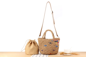 Detail of handmade woven straw tote bag with brown leather strap and inner canvas pouch